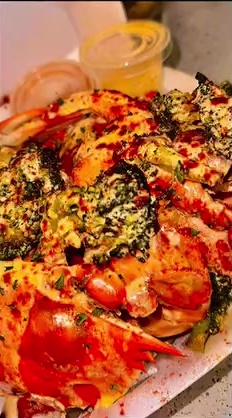 Platter of crab legs and seafood topped with herbs and butter sauce